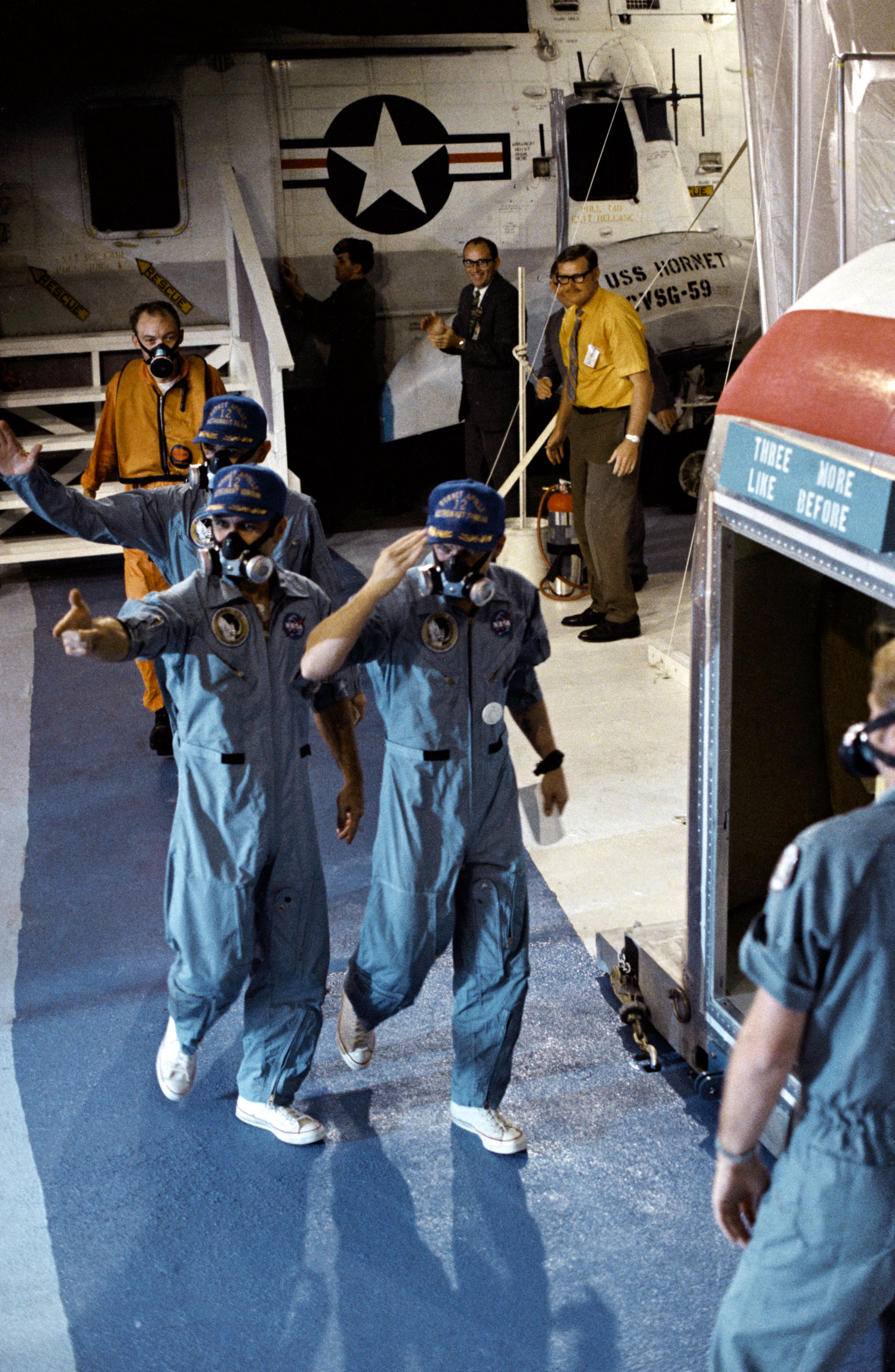 Conrad, front, Gordon, and Bean walk from the helicopter to the Mobile Quarantine Facility