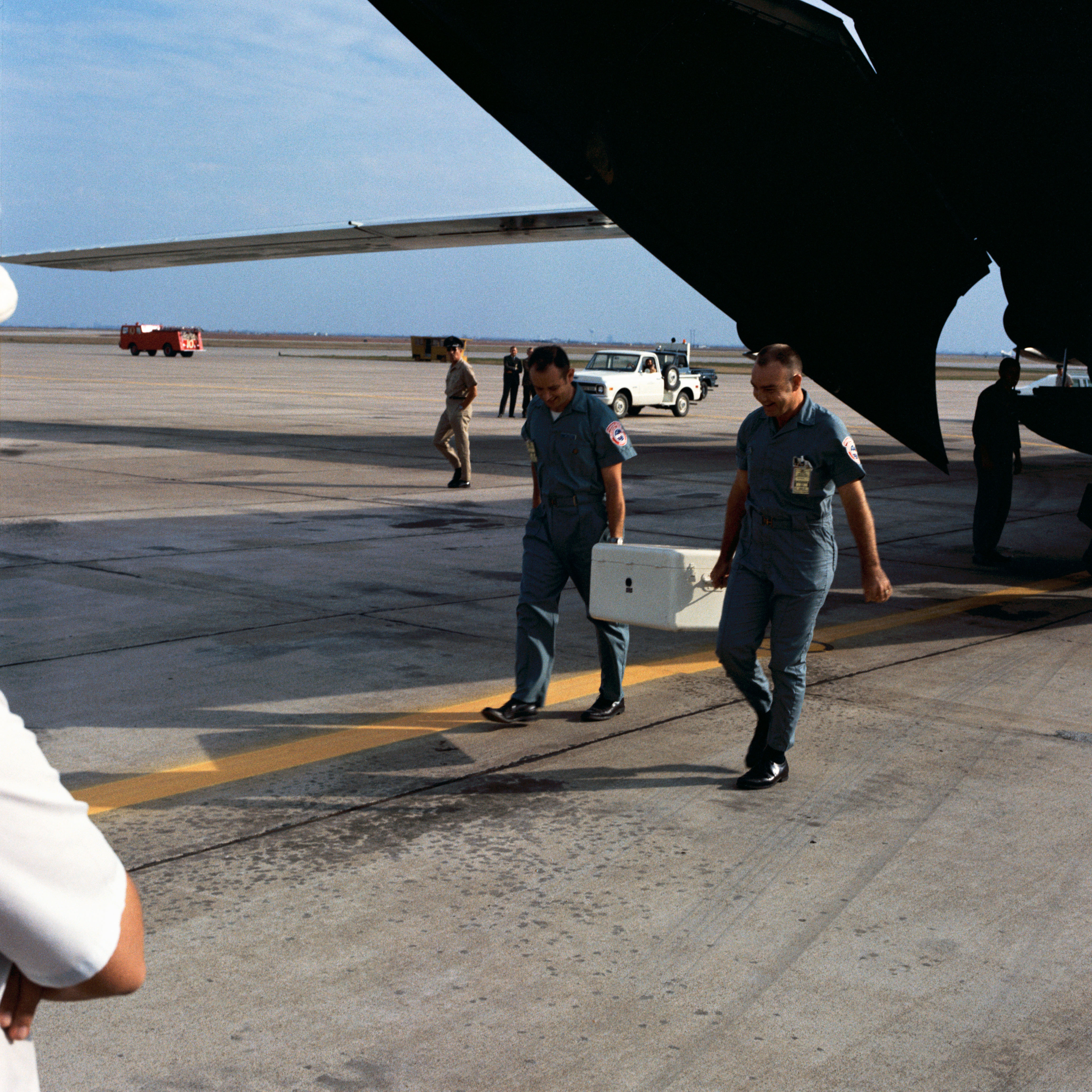 Technicians carry the first box of Apollo 12 lunar samples from the cargo plane after its arrival at Ellington Air Force Base in Houston