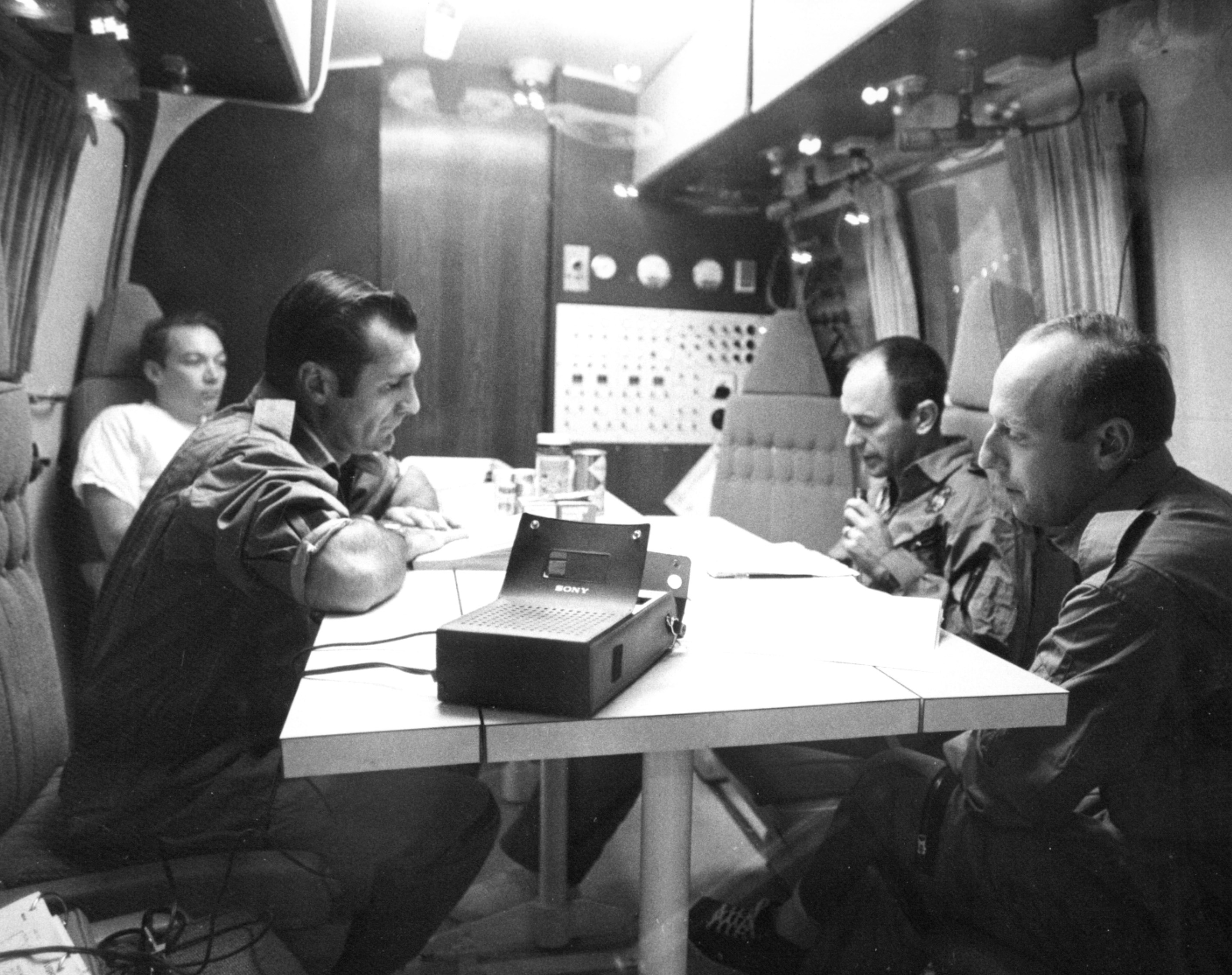 Apollo 12 astronauts Richard F. Gordon, second from left, Alan L. Bean and Charles “Pete” Conrad prepare their mission report inside the MQF