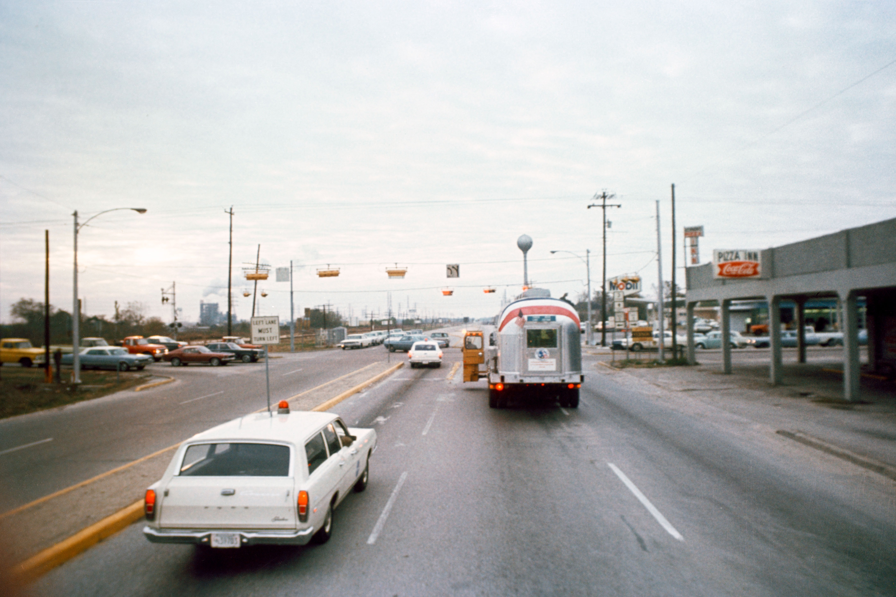 Workers drive the Apollo 12 astronauts inside the Mobile Quarantine Facility (MQF) from Ellington Air Force Base to the Manned Spacecraft Center