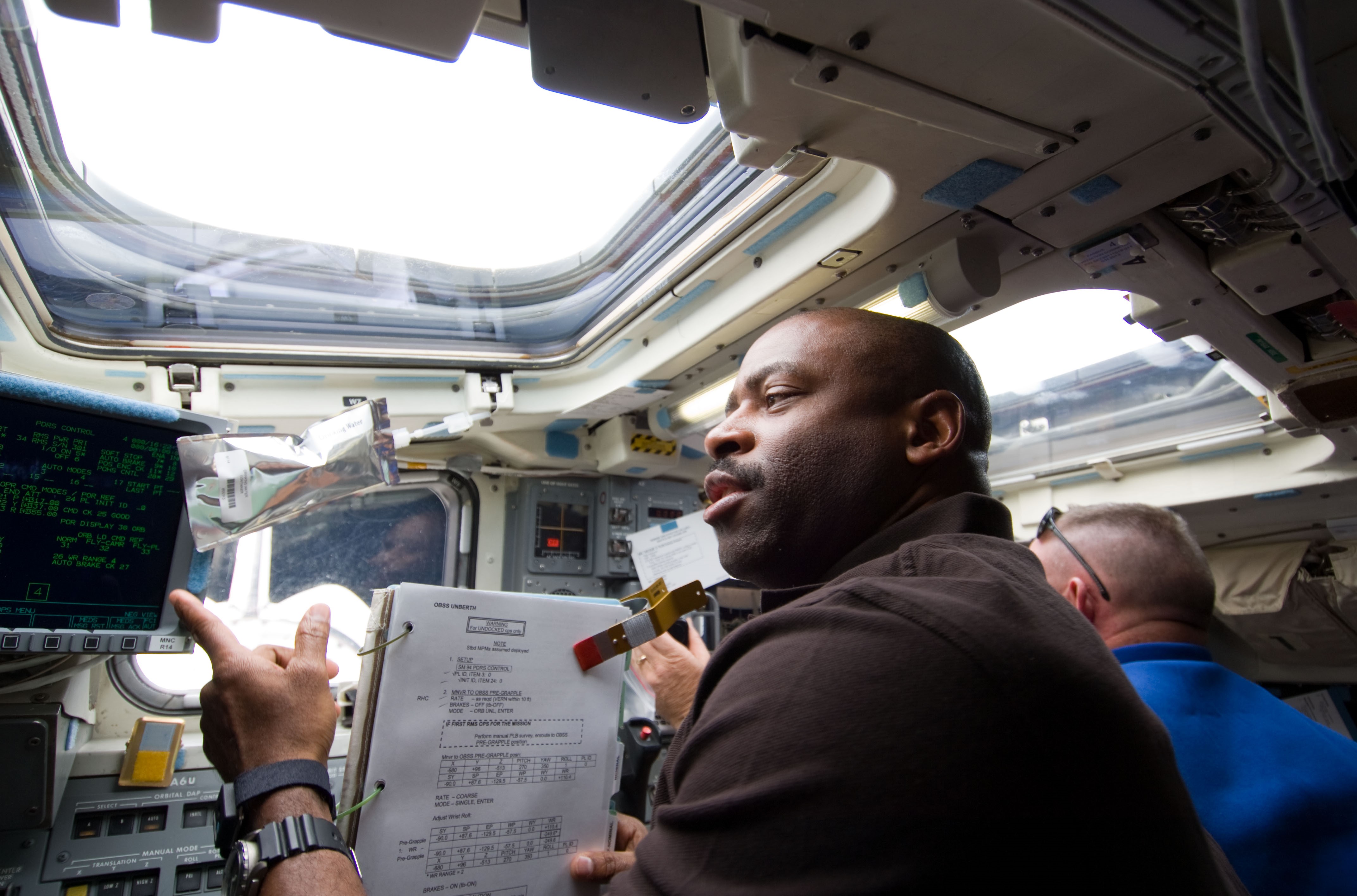 Leland D. Melvin participates in the inspection of Atlantis’ thermal protection system