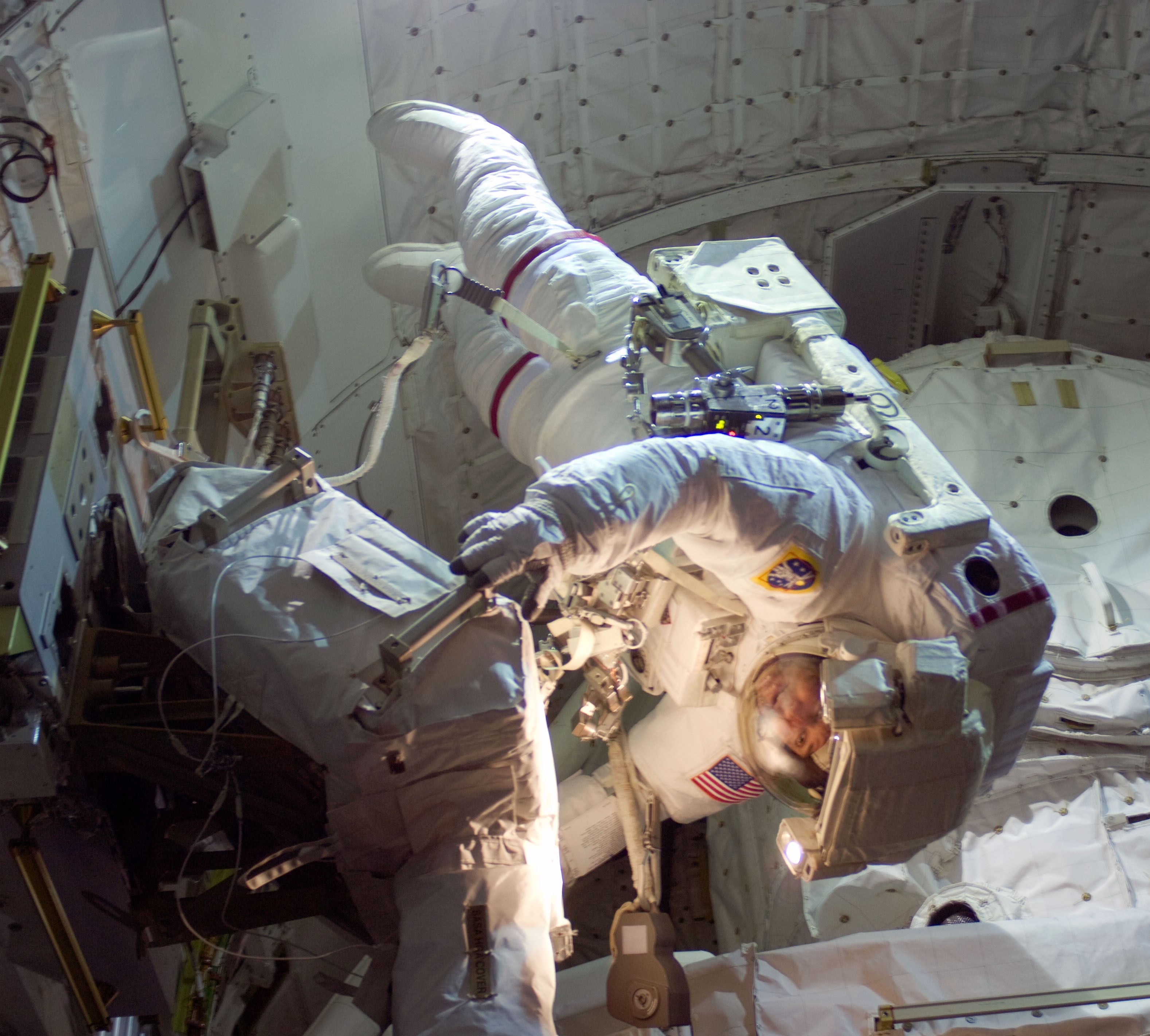 Michael J. Foreman unstows the S-band Antenna Support Assembly prior to transferring it to the station