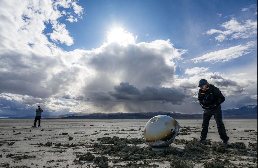 A heat shield made by NASA is visible on the blunt, upward-facing side of a space capsule after its landing in the Utah desert.