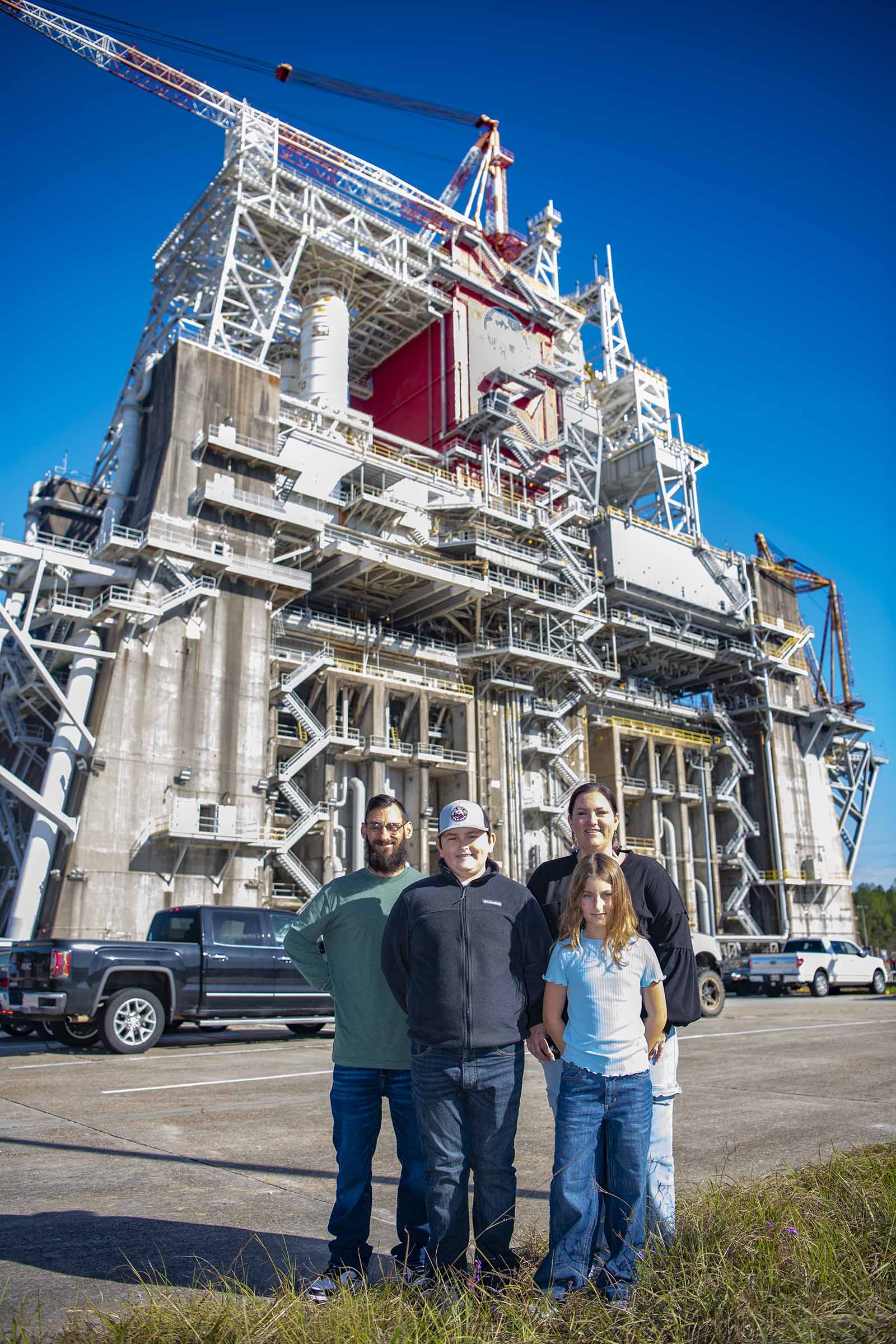 Cookbook author and culinary content creator Caroline Davis, popularly known as Mississippi Kween, and her family pose for a portrait in front of the Thad Cochran Test Stand during their visit to NASA Stennis